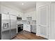 A modern kitchen with stainless steel appliances, white cabinets, and a tile backsplash on wood-look floor at 336 Center Lake Ln # A-2, Oviedo, FL 32765