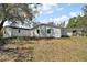 View of home's backyard and separate structure, beneath a shady tree and blue sky at 33830 S Haines Creek Rd, Leesburg, FL 34788
