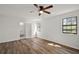 Bright bedroom features wood-look floors, ceiling fan, and ample natural light at 33830 S Haines Creek Rd, Leesburg, FL 34788