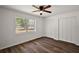 Bedroom features wood-look floors, ceiling fan, and a large window at 33830 S Haines Creek Rd, Leesburg, FL 34788