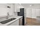 Kitchen with stainless sink, dishwasher, refrigerator, and white quartz countertop at 33830 S Haines Creek Rd, Leesburg, FL 34788