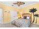 Comfortable bedroom featuring palm tree wall art, rattan furniture, and a ceiling fan at 3936 Parkhouse Dr, Orlando, FL 32824