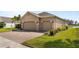 A spacious three-car garage featuring a brick driveway and verdant green landscaping at 3936 Parkhouse Dr, Orlando, FL 32824