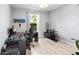 A home office with light hardwood flooring, a large window and a modern desk setup at 3936 Parkhouse Dr, Orlando, FL 32824