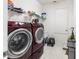 A laundry room equipped with a washer, dryer, and shelving for storage at 3936 Parkhouse Dr, Orlando, FL 32824