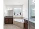 Bright bathroom with a soaking tub, granite counters, tile floor, and a window with decorative plants at 3936 Parkhouse Dr, Orlando, FL 32824