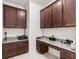 Functional home office with built-in desk, granite countertops, and dark wood cabinetry at 3936 Parkhouse Dr, Orlando, FL 32824