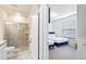 Modern bathroom with glass-enclosed shower and bedroom with blue beds in view at 3966 Lana Ave, Davenport, FL 33897
