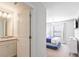 Modern bathroom featuring a vanity with granite countertop, connecting to the bedroom with comfortable bed at 3966 Lana Ave, Davenport, FL 33897