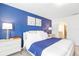 Bright bedroom with blue accent wall, modern nightstands, and comfortable king-size bed with plush bedding at 3966 Lana Ave, Davenport, FL 33897