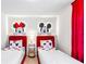 Fun ' bedroom featuring twin beds with Mickey Mouse decor, themed lighting, and bright red curtains at 3966 Lana Ave, Davenport, FL 33897