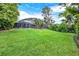 Sprawling backyard featuring lush green lawn and screened-in pool enclosure at 408 Almeria Ct, Winter Springs, FL 32708