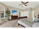 Comfortable main bedroom featuring a ceiling fan, television, and a cozy sitting area at 408 Almeria Ct, Winter Springs, FL 32708