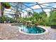 Screened pool features a waterfall and beautiful landscaping with lush trees and foliage at 408 Almeria Ct, Winter Springs, FL 32708
