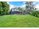 A screened-in pool area features palm trees and ample green space, creating a private backyard oasis at 408 Almeria Ct, Winter Springs, FL 32708