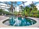 Beautiful screened-in pool featuring a rock waterfall feature with tropical plants at 408 Almeria Ct, Winter Springs, FL 32708