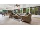 Bright and airy sunroom with wicker furniture, tile flooring, and views of the lush backyard at 408 Almeria Ct, Winter Springs, FL 32708