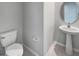 Cozy half-bathroom with pedestal sink and a round mirror at 4346 Trotters Way, Lakeland, FL 33801