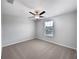 Bright bedroom featuring a ceiling fan, neutral paint, plush carpeting, and a sun-filled window at 4346 Trotters Way, Lakeland, FL 33801