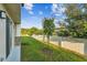 Well-maintained backyard with lush green grass, a young tree, and a white privacy fence at 4461 Summer Flowers Pl, Kissimmee, FL 34746