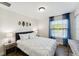 Comfortable bedroom with a queen bed, wood floors, and neutral decor, basking in natural light at 4461 Summer Flowers Pl, Kissimmee, FL 34746