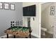 A bright game room with a foosball table, decor and a mounted TV, with adjacent bathroom access at 4461 Summer Flowers Pl, Kissimmee, FL 34746