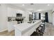 Bright kitchen features a quartz countertop island with seating, stainless steel appliances and white cabinetry at 4461 Summer Flowers Pl, Kissimmee, FL 34746