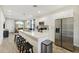 Bright, open kitchen with stainless steel appliances, white cabinets and an island with bar stool seating at 4461 Summer Flowers Pl, Kissimmee, FL 34746