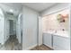 Functional laundry room with washer, dryer, storage shelves, and well-lit hallway access at 4461 Summer Flowers Pl, Kissimmee, FL 34746