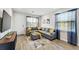 Bright living room with comfortable gray sectional, blue curtains, and wood-look floors at 4461 Summer Flowers Pl, Kissimmee, FL 34746