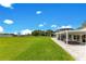 Expansive backyard with a covered patio, lush green lawn, and waterfront views at 49 Interlaken Rd, Orlando, FL 32804