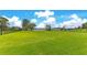 Spacious backyard with a green lawn surrounded by a black fence and waterfront views at 49 Interlaken Rd, Orlando, FL 32804
