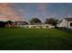Large grassy backyard featuring modern luxury homes, a black fence, and lush green grass at 49 Interlaken Rd, Orlando, FL 32804
