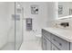 Bathroom featuring tiled shower, modern vanity with gray cabinets, and stylish fixtures at 49 Interlaken Rd, Orlando, FL 32804