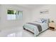 Bright bedroom with marble floors, a modern bed with blue accents, and natural light from a large window at 49 Interlaken Rd, Orlando, FL 32804