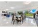 The elegant dining area includes a glass table and seating for eight, with views of the lush backyard at 49 Interlaken Rd, Orlando, FL 32804