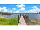 Dock featuring a wooden walkway with views of the calm lake and lush lakeside greenery at 49 Interlaken Rd, Orlando, FL 32804