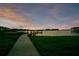 Inviting lakefront views showcase a picturesque wooden dock leading into tranquil waters at sunset at 49 Interlaken Rd, Orlando, FL 32804