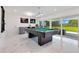 Bright game room with a billiard table, wet bar, marble floors, and large glass doors to backyard at 49 Interlaken Rd, Orlando, FL 32804