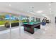 Bright game room with a pool table and sliding glass doors overlooking a scenic outdoor view at 49 Interlaken Rd, Orlando, FL 32804
