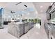 A gourmet kitchen features a large granite island, stainless appliances, and seamless flow to dining and living areas at 49 Interlaken Rd, Orlando, FL 32804