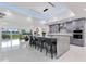 The contemporary kitchen boasts seating at a granite island, sleek cabinets, and views of the outdoor dining area at 49 Interlaken Rd, Orlando, FL 32804