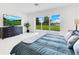Bedroom with large windows looking to the backyard and a sleek dresser with wall-mounted TV at 49 Interlaken Rd, Orlando, FL 32804
