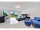 Modern bedroom with marble floors, large windows with backyard view, blue decor, and lounge seating at 49 Interlaken Rd, Orlando, FL 32804