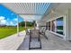 Covered outdoor patio featuring a dining table, seating, and a built-in outdoor kitchen area at 49 Interlaken Rd, Orlando, FL 32804