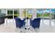 A cozy sitting area with plush blue chairs provides serene views of the backyard and waterfront at 49 Interlaken Rd, Orlando, FL 32804