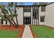 Beautiful front exterior with black and white trim, lush green grass, and a concrete walkway leading to the front door at 4940 Spring Run Ave, Orlando, FL 32819