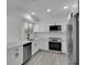 Modern kitchen with white cabinets, stainless appliances, granite countertops, and ample lighting at 4940 Spring Run Ave, Orlando, FL 32819