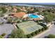 Aerial view of community pool, tennis courts, clubhouse and surrounding homes at 5007 Belted Kingfisher Dr, Oxford, FL 34484