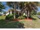 Home exterior featuring a screened lanai and lush landscaping in the backyard at 5007 Belted Kingfisher Dr, Oxford, FL 34484
